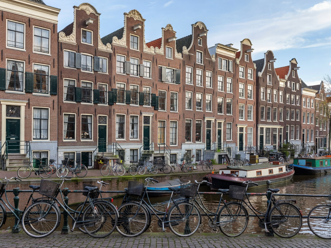 Amsterdam historic brick row houses along canal with bicycles